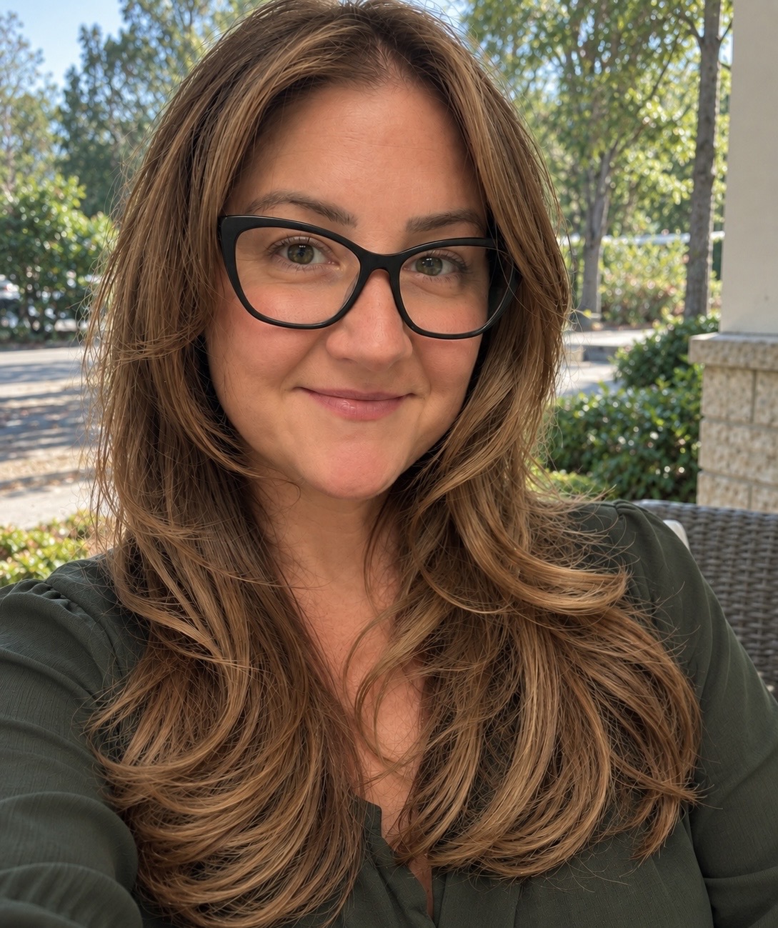 Founder of Bee Yourself outdoors wearing a green blouse